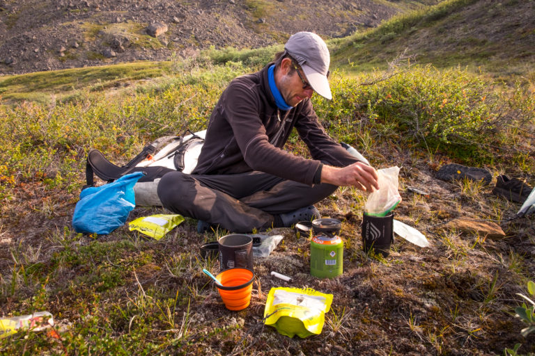 Hiker preparing meal on the Arctic Circle Trail. Food is an important consideration when packing for the ACT