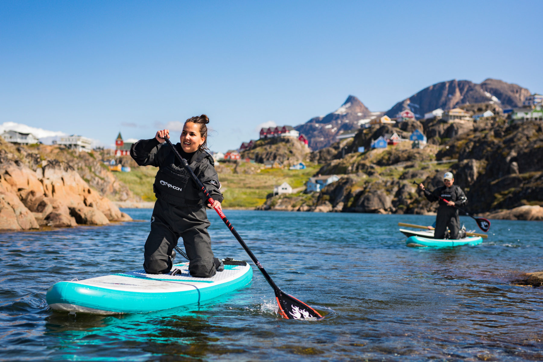 People stand-up-paddleboarding near Sisimiut