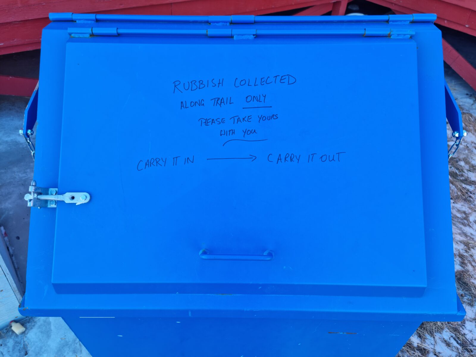 Reminder message to take your own trash with you, written on the lid of the bins at each hut along the Arctic Circle Trail