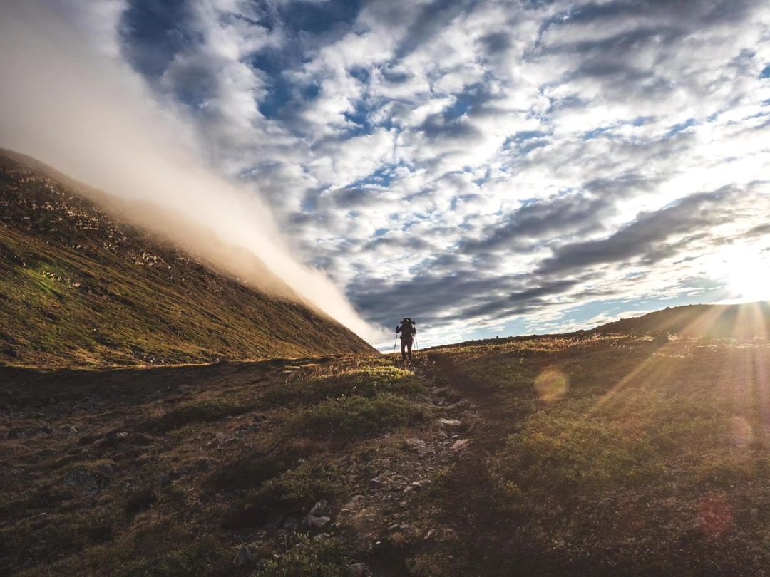 Hiker on Greenland's Arctic Circle Trail with the sun low in the sky